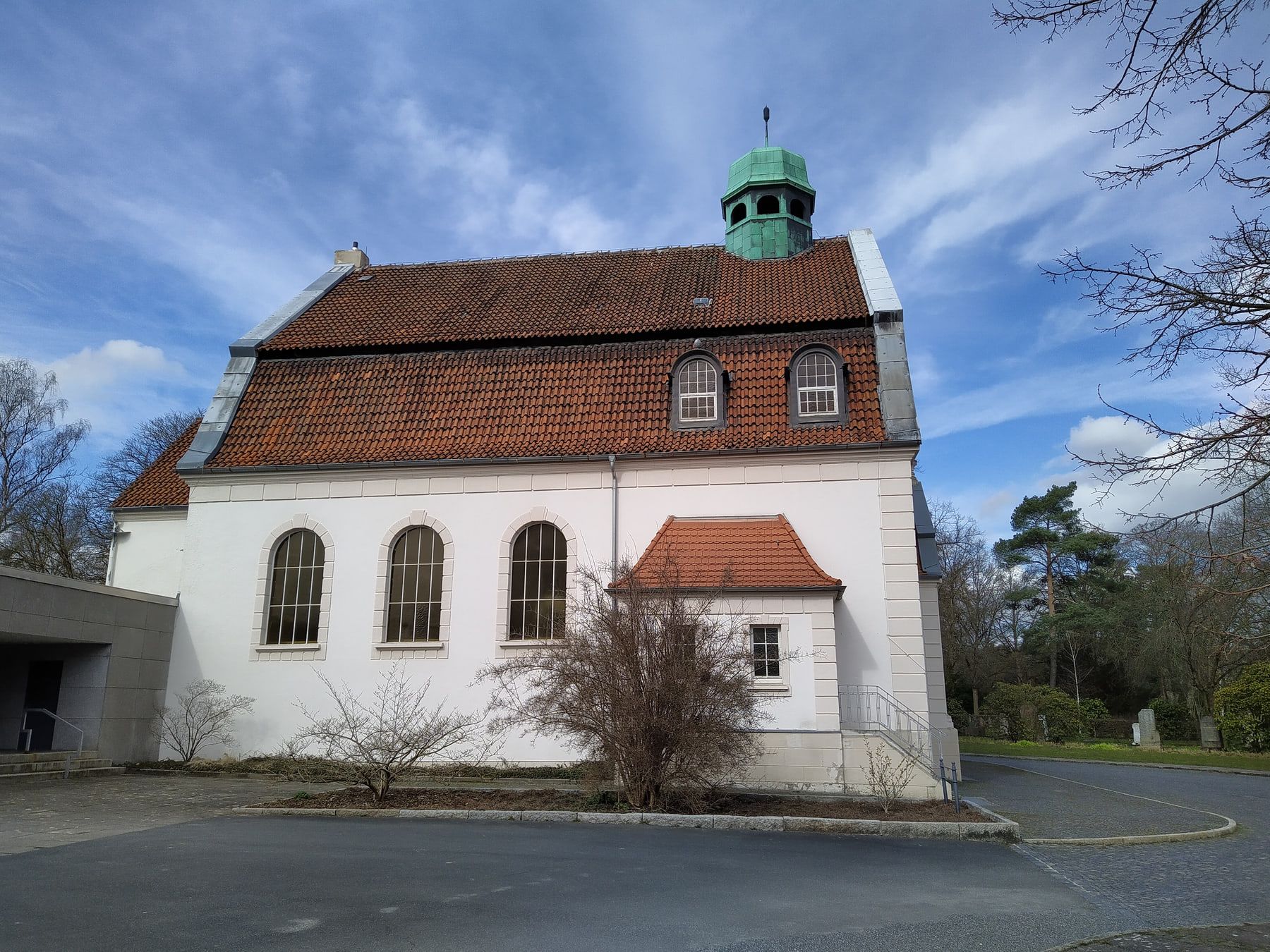 Südansicht der Alten Kapelle mit weißer Fassade und rotem Ziegeldach auf Stadtfriedhof Ricklingen